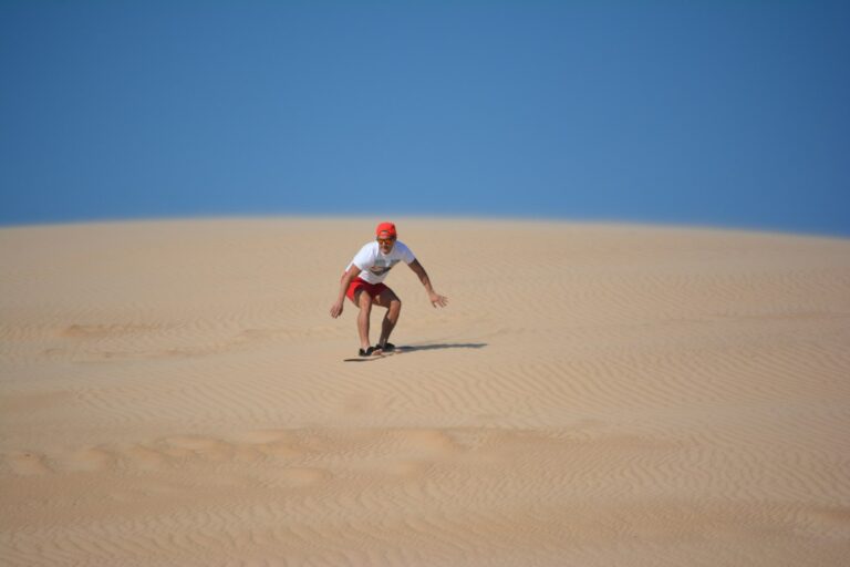 Sandboarding down a desert dune